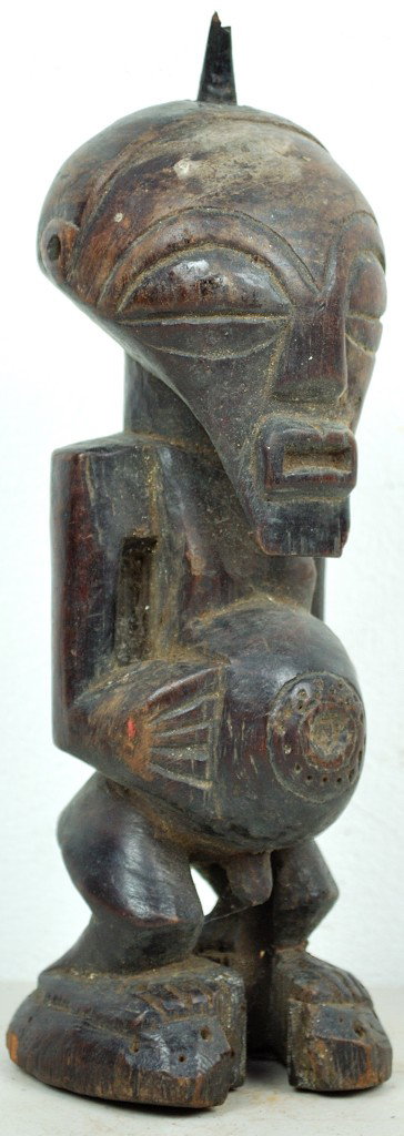 A SONGYE TRIBE CARVED WOOD FETISH - ZAIRE: A SONGYE TRIBE CARVED WOOD FETISH - ZAIRE Horn on head covered with fetish material. Stomach probably had similar material at one time. 10 x 3 x 3½ inches