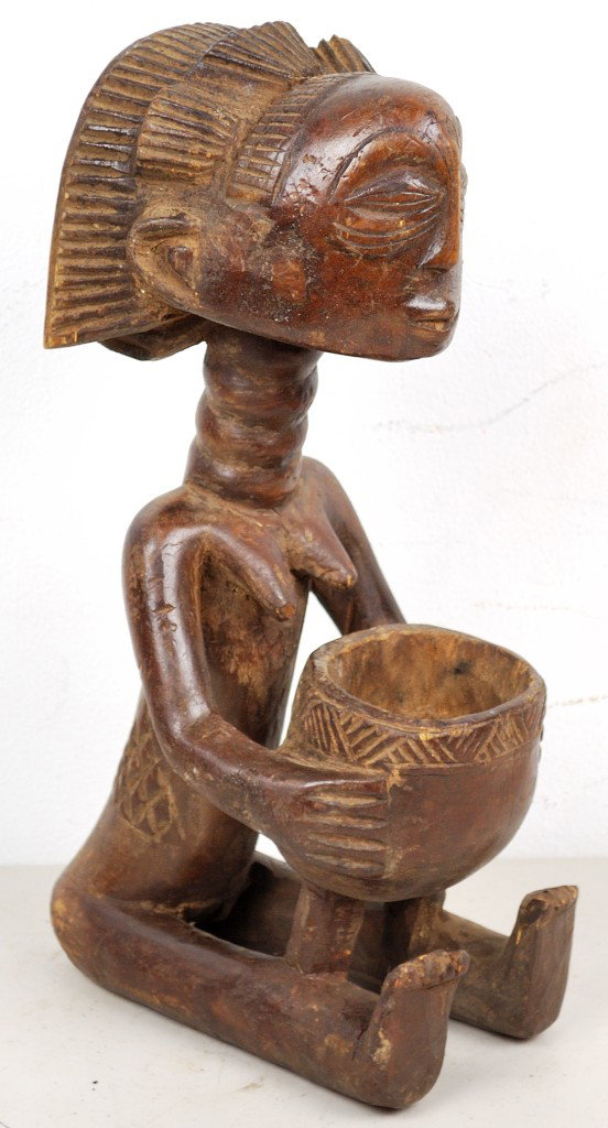 A CARVED WOODEN LUBA TRIBE FEMALE FIGURE - ZAIRE: A CARVED WOODEN LUBA TRIBE FEMALE FIGURE - ZAIRE Figure holds a bowl. Probably ceremonial for magic. 14 x 5 x 8 inches