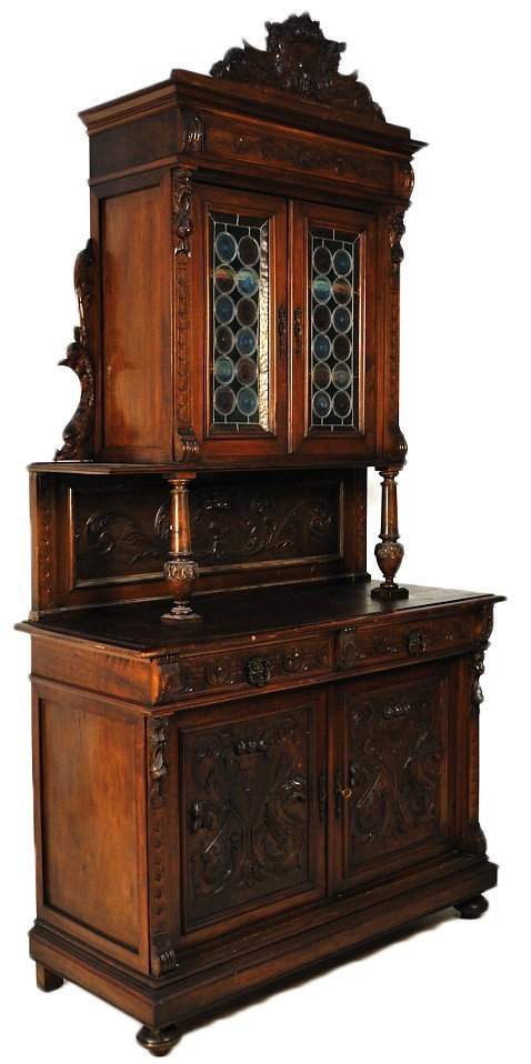A 19TH CENTURY RENAISSANCE REVIVAL SIDEBOARD WITH M: A 19TH CENTURY RENAISSANCE REVIVAL SIDEBOARD WITH MULTI COLOR LEADED GLASS DOORS Elaborately carved panels and crest feature sea serpents 101 x 53½ x 22 inches