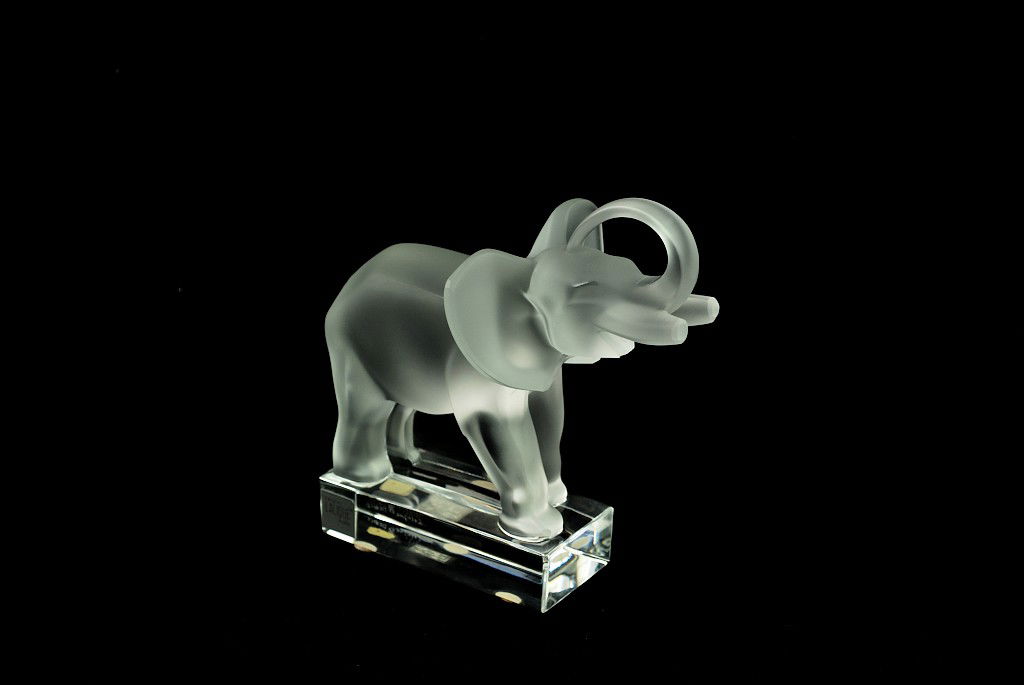 A LALIQUE ETCHED CRYSTAL ELEPHANT France Condition: A LALIQUE ETCHED CRYSTAL ELEPHANT France The elephant depicted with its trunk curled up over the head and displaying truncated tusks, the open mouth with a playful expression. SIgned ""Lalique copyrig