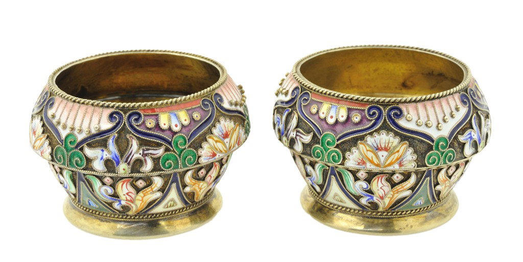 A PAIR OF RUSSIAN SILVER AND ENAMEL SALT & PEPPER : A PAIR OF RUSSIAN SILVER AND ENAMEL SALT & PEPPER CUPS Circa 1900, BY FYODOR RUCH Gold wash interior over silver. A footed urn form body with delicate high relief of pedant pearl forms, scroll work an