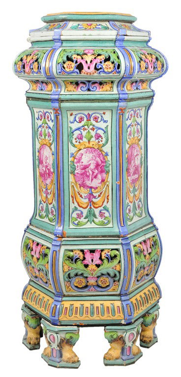 A RARE ITALIAN FAIENCE COAL FIRED FREE STANDING CHI: A RARE ITALIAN FAIENCE COAL FIRED FREE STANDING CHIMNEY PIECE, Early 20th century The octagonal undulating ceramic body with pierced scroll work flares to a bulbous body adorned with hand painted rasp