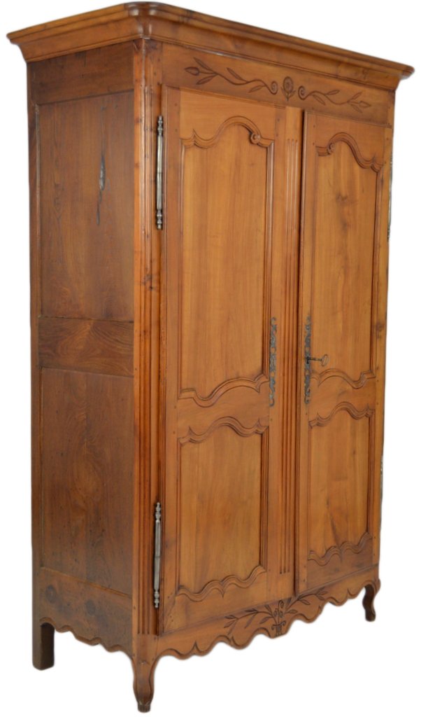 A FRENCH PROVINCIAL CHERRY ARMOIRE: A FRENCH PROVINCIAL CHERRY ARMOIRE The molded cornice above an incised frieze is supported by a rectilinear body with Louis XV style doors with two shaped reserves each and fluted astragal. Raised on 