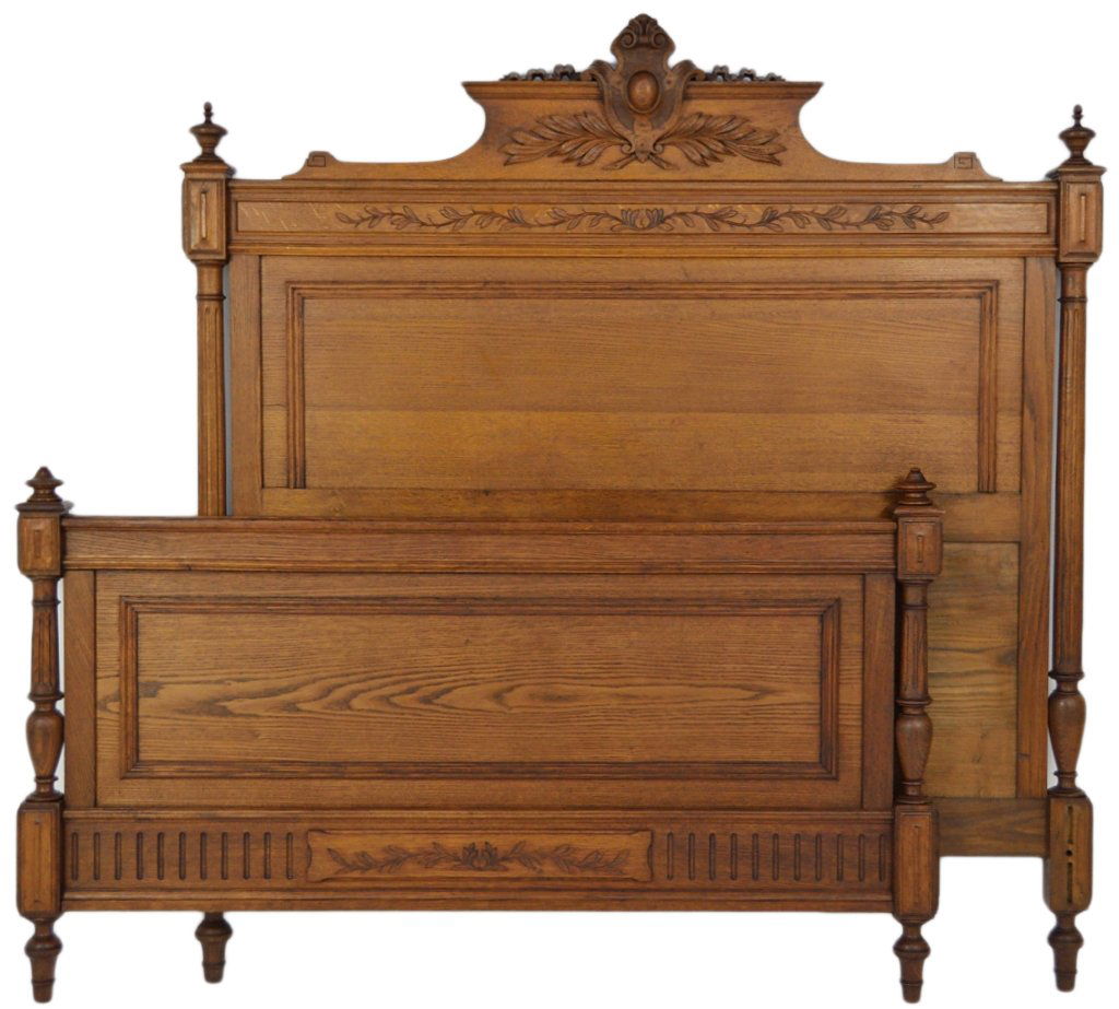 A HENRI II STYLE CARVED WALNUT BED: A HENRI II STYLE CARVED WALNUT BED The headboard features a beautiful carved cartouche with cabochon over a laurel leaf garland. Incised carved leaf garlands within horizontal accents at both head and