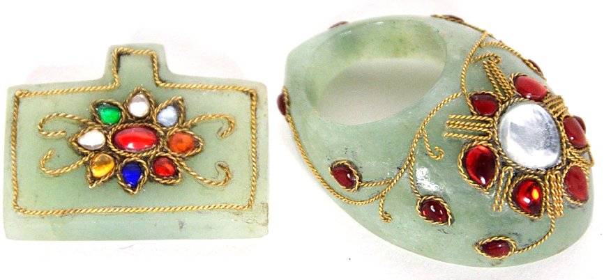 TWO PIECES OF MUGHAL STYLE CARVED JADE: TWO PIECES OF MUGHAL STYLE CARVED JADE 20th Century An Archery Thumb Ring and Jade Pendent. Both of carved and decorated jade with stone sets. 2 x 5½ x 4 inches
