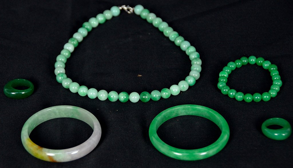 A LOT OF SIX CARVED JADE JEWELRY ITEMS: A LOT OF SIX CARVED JADE JEWELRY ITEMS Probably Chinese; of varying colors of jade; including two rings, two bangle bracelets, a beaded bracelet, and a beaded necklace. Necklace: 16 inch length. Lengt