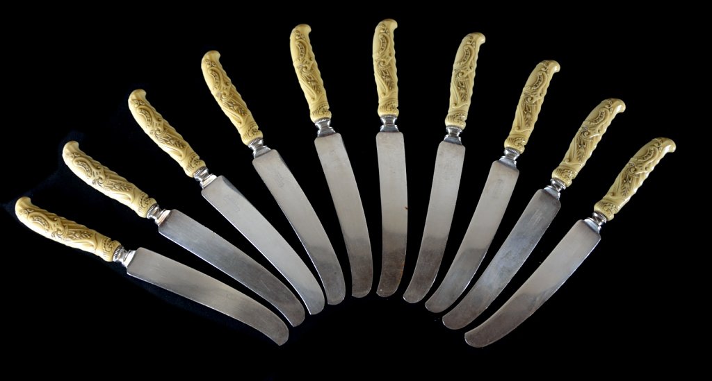 A SET OF TEN UNIVERSAL IVORY HANDLED KNIVES: A SET OF TEN UNIVERSAL IVORY HANDLED KNIVES Early 20th Century, American Each knife having a carved ivory handle decorated with flowers and C-scrolls; the blade with maker's mark on one side. Length: 
