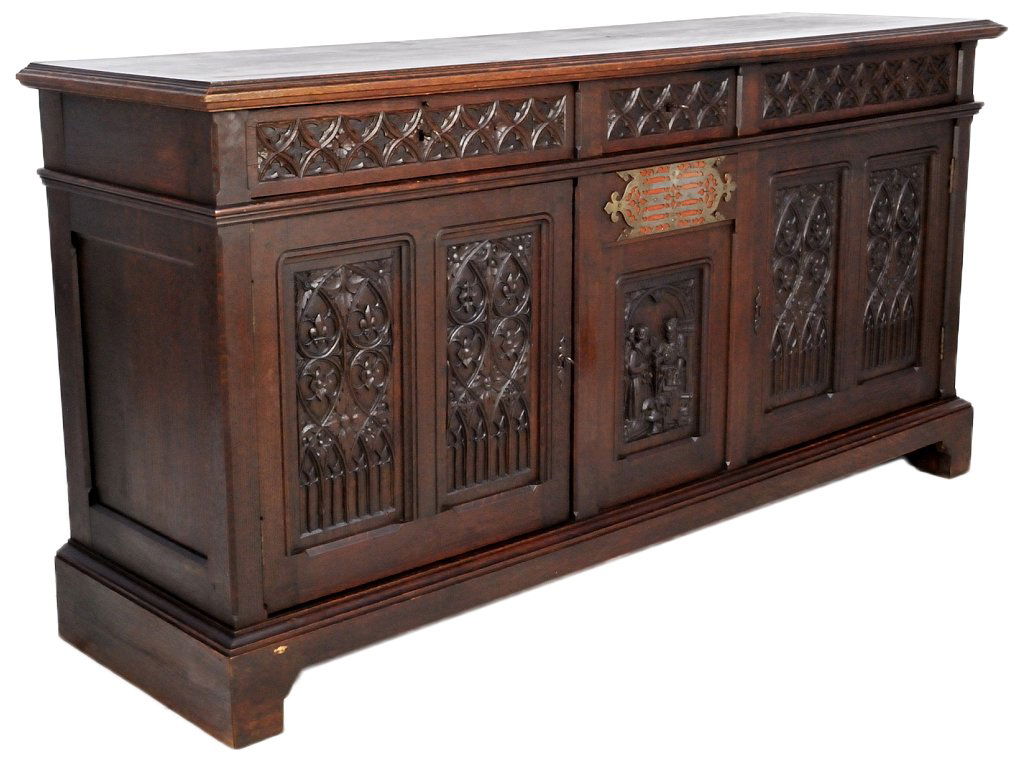 A GOTHIC STYLE CARVED OAK CREDENZA: A GOTHIC STYLE CARVED OAK CREDENZA Late 19th Century Most likely eclesiastical. Pegged and dove tailed construction. Beautifully carved gothic motifs adorn the door and drawer panels, with a pierce cu