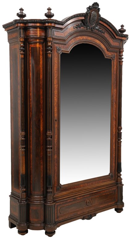 A NAPOLEON III STYLE ROSEWOOD AND BURL ELMWOOD ARM: A NAPOLEON III STYLE ROSEWOOD AND BURL ELMWOOD ARMOIRE 19th Century A carved and ebonized crest surmounts an arched, moulded cornice with radius corners, four urn finials supported by four free standi