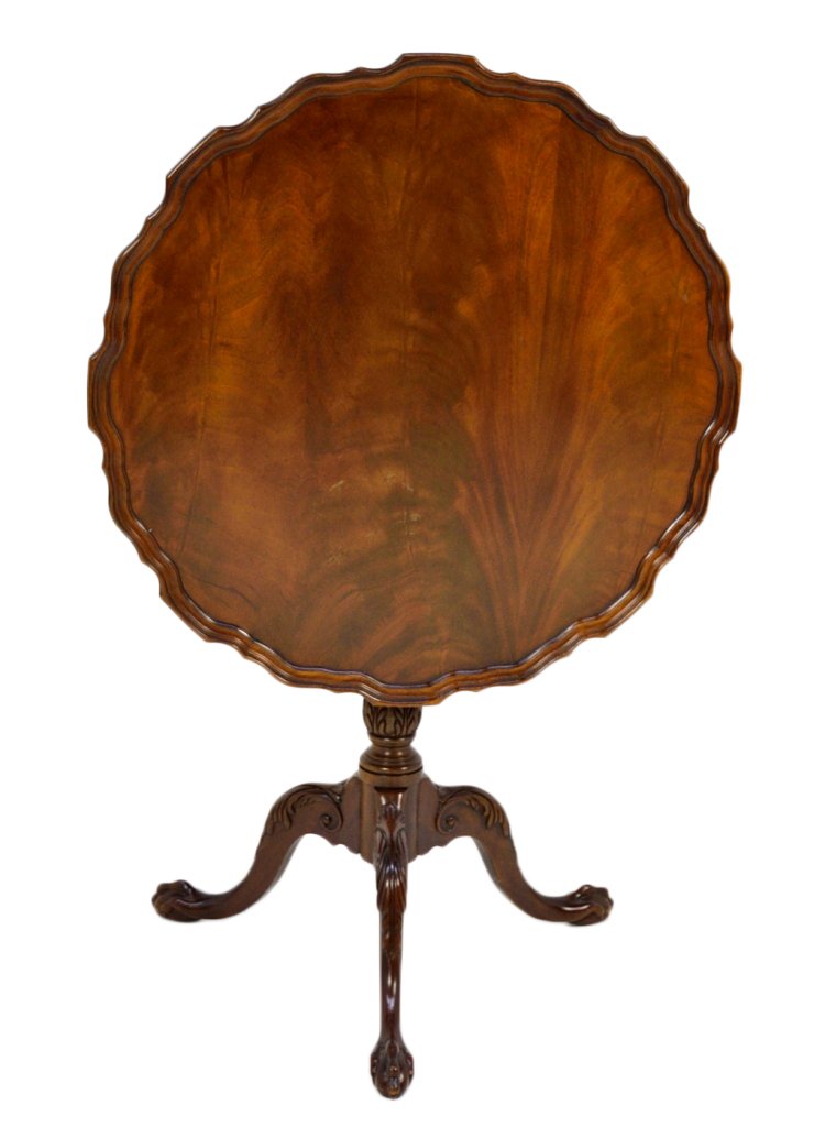 A CHIPPENDALE STYLE MAHOGANY PIE CRUST TILT TOP TAB: A CHIPPENDALE STYLE MAHOGANY PIE CRUST TILT TOP TABLE 20th Century The round top with crimped and molded edge, vase turned central post supported on tri-pod spade foot with carved decoration. 45½ x 3