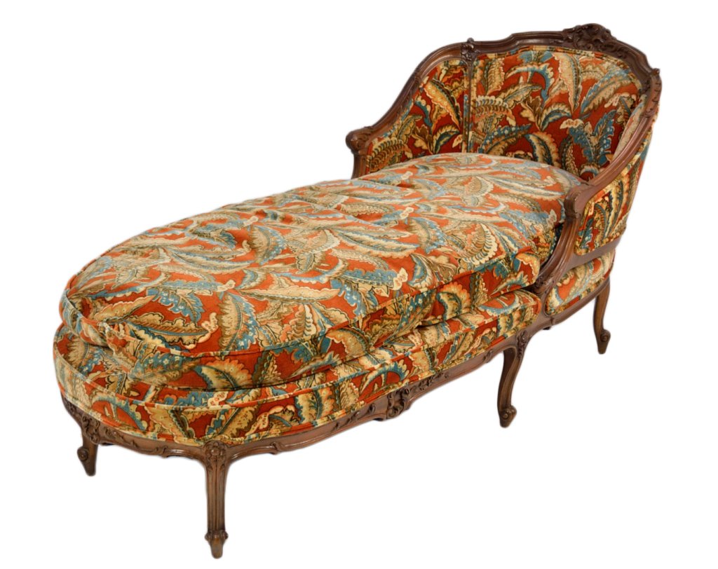 A LOUIS XV STYLE CARVED WALNUT CHAISE LONGUE: A LOUIS XV STYLE CARVED WALNUT CHAISE LONGUE Late 19th Century A hand carved, floral and foliate, six leg, elongated bergere frame with printed velvet cover. 34 x 30½ x 69 inches