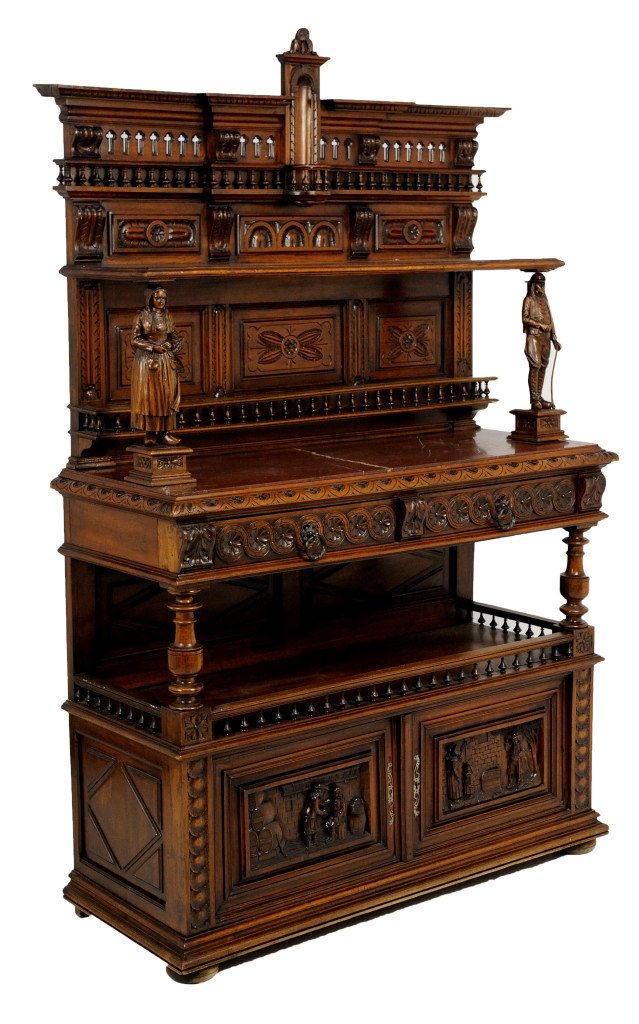 FIGURAL CARVED BRITTANY STYLE WALNUT SIDEBOARD: FIGURAL CARVED BRITTANY STYLE WALNUT SIDEBOARD 19th Century Heavily carved all over with scenic panels and regional figures, turned spindles create plate rack and gallery rail. A tiny cathedral style 