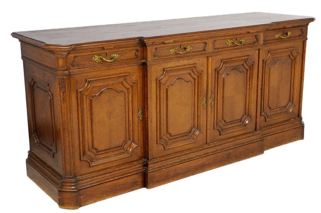 FRENCH REGENCY STYLE OAK SIDEBOARD: FRENCH REGENCY STYLE OAK SIDEBOARD Late 19th - early 20th Century Raised panel construction, plinth base, four doors with stepped center. Three pull out butlers shelf above drawers, largest at center,