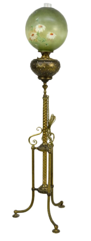 AN ELECTRIFIED VICTORIAN STANDING OIL LAMP: AN ELECTRIFIED VICTORIAN STANDING OIL LAMP 19th Century Ornate tripod base stand with large oil pot supporting a hand painted floral glass shade and chimney. 58 x 16 x 16 inches