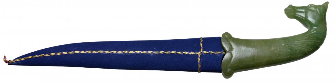 MUGHAL STYLE JADE-HANDLED DAGGER IN SHEATH: MUGHAL STYLE JADE-HANDLED DAGGER IN SHEATH India, 20th Century The dagger having a carved spinach jade handle ending in a horse's head and neck; the blacked blade with elaborate silver-toned designs, 