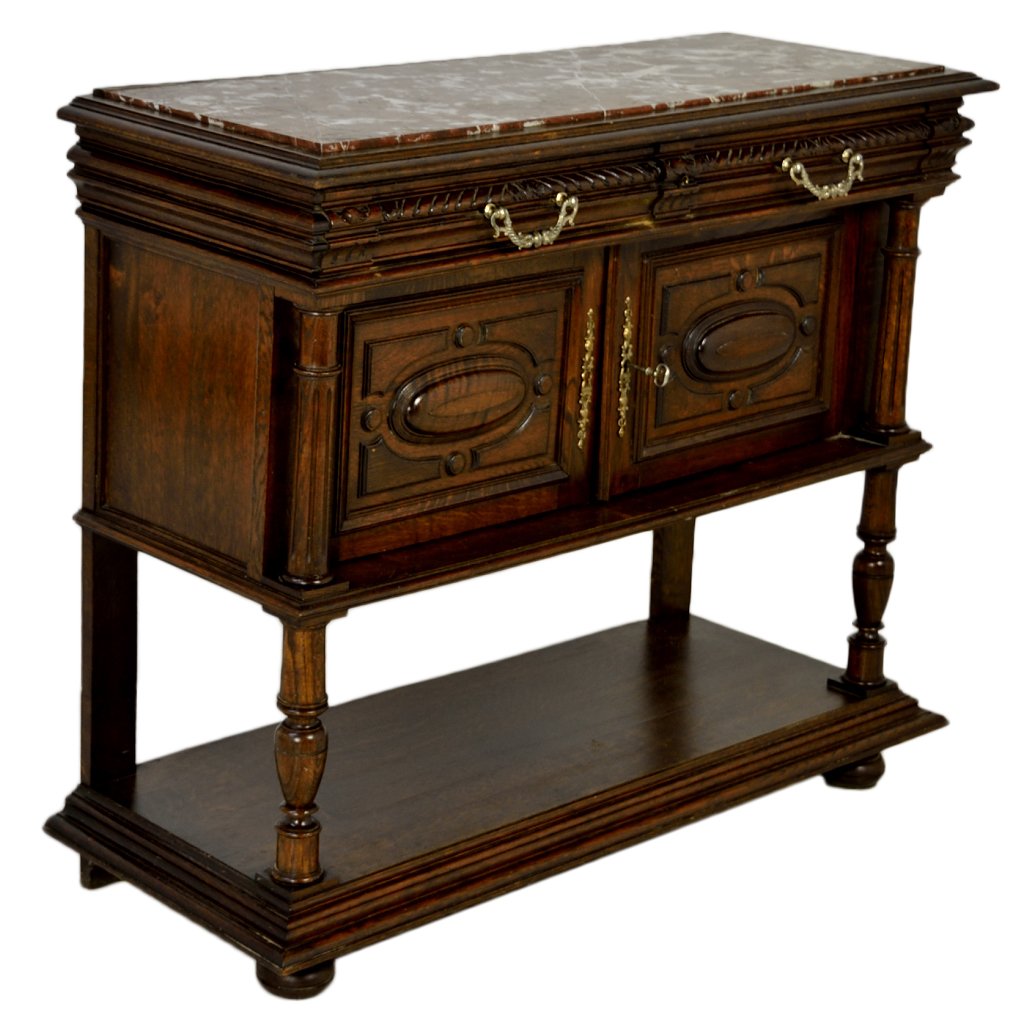 FRENCH VICTORIAN MARBLE TOP SIDEBOARD: FRENCH VICTORIAN MARBLE TOP SIDEBOARD 19th Century Solid Oak; inset rouge marble top, two carved face freize drawers with ornate bronze pulls, overhanging a cabinet having cabochon paneled doors, flan