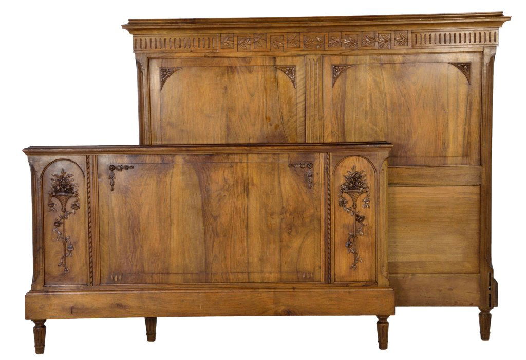 LOUIS XVI STYLE CARVED WALNUT BED: LOUIS XVI STYLE CARVED WALNUT BED France, Early 20th Century Walnut; the double panel headboard with flute carved frieze panel, the foot board, with a central rectangular panel flanked by two arched p