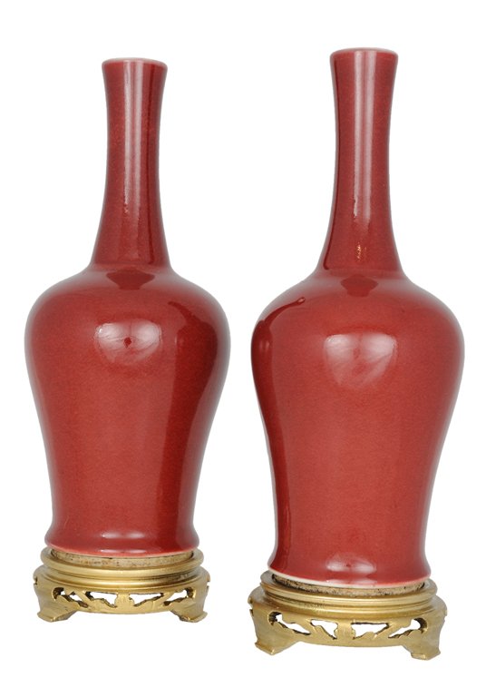 A PAIR OF DIMINUTIVE CHINESE ANTIQUE OXBLOOD PORCE: A PAIR OF DIMINUTIVE CHINESE ANTIQUE OXBLOOD PORCELAIN AMPHORA ON STANDS Early 20th Century The Ming style forms feature delicate everted lips atop elongated necks of baluster form vases; each amphora