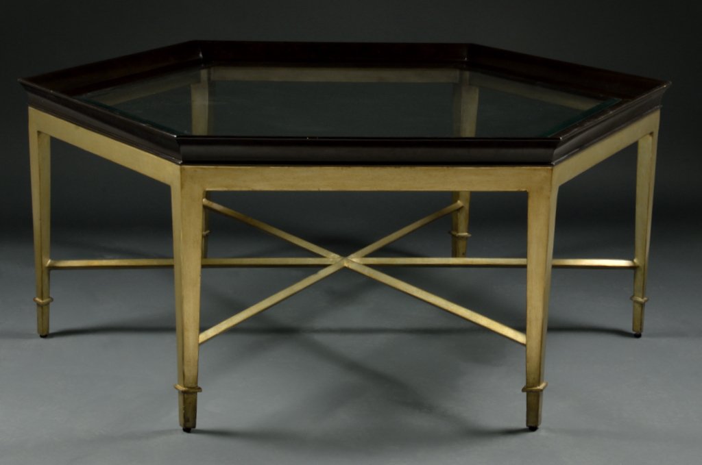 SILVER GILT AND EBONIZED COCKTAIL TABLE: SILVER GILT AND EBONIZED COCKTAIL TABLE 21st Century A sleek wood base with tapering straight legs and crossing center stretchers, ebonized picture frame edge of the octagon top holds a fitted plate g