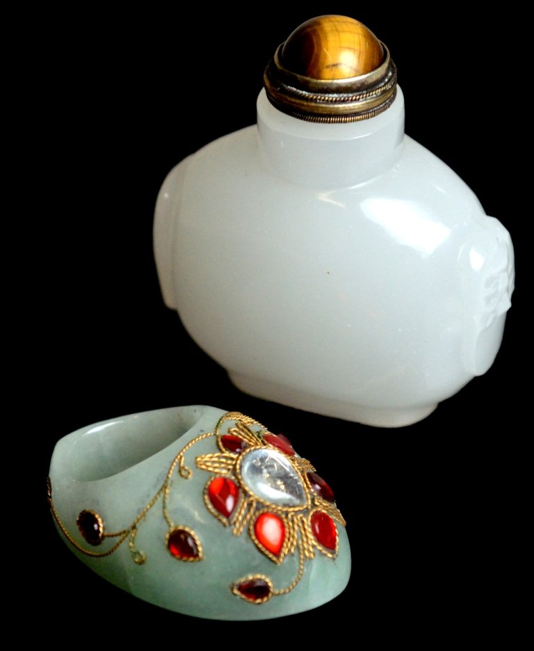 JADE SNUFF BOTTLE AND ARCHERY RING: JADE SNUFF BOTTLE AND ARCHERY RING 20th Century, Asia The large Chinese snuff bottle carved of white jade in a flattened baluster form, with a cat's eye cabochon atop the stopper. The Mughal style arc