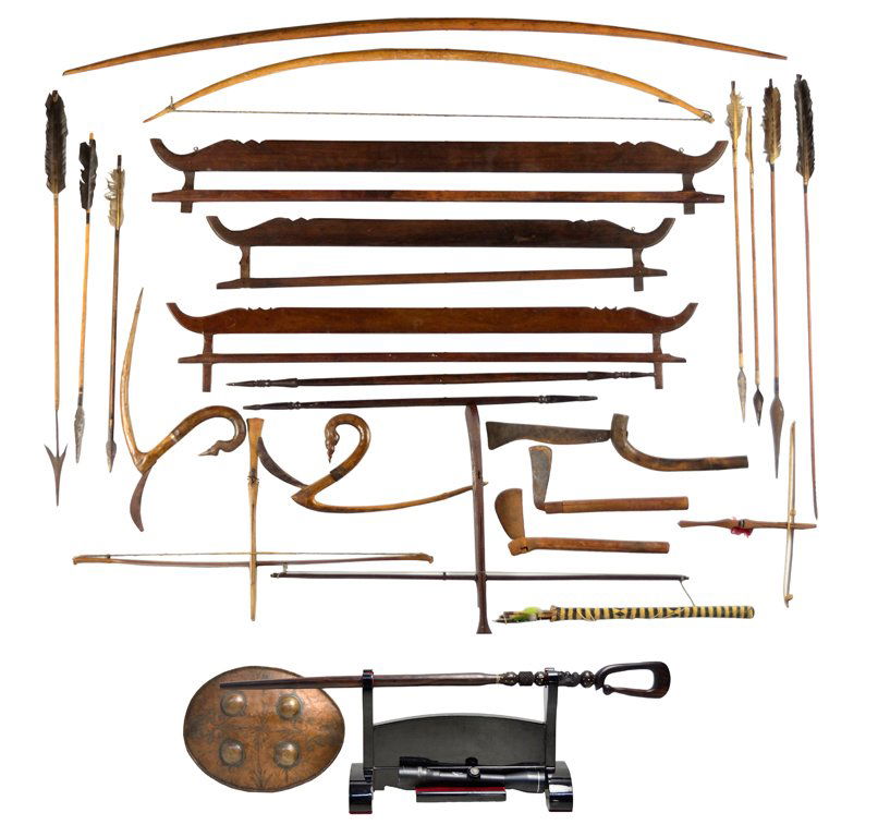 A DECORATIVE AND VINTAGE AFRICAN SAFARI GROUPING: A DECORATIVE AND VINTAGE AFRICAN SAFARI GROUPING 20th Century, Africa A collection of African implements includes arrows with feathers, carved spears, a curved walking stick, various farm tools, bows,