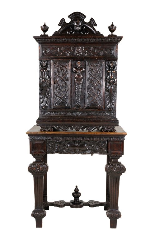 AN ANTIQUE RENAISSANCE STYLE WALNUT CABINET ON STA: AN ANTIQUE RENAISSANCE STYLE WALNUT CABINET ON STAND Italy, 18th Century The arched cornice with carved mask is flanked by delicate finials supported by a rectilinear cabinet featuring relief carved f