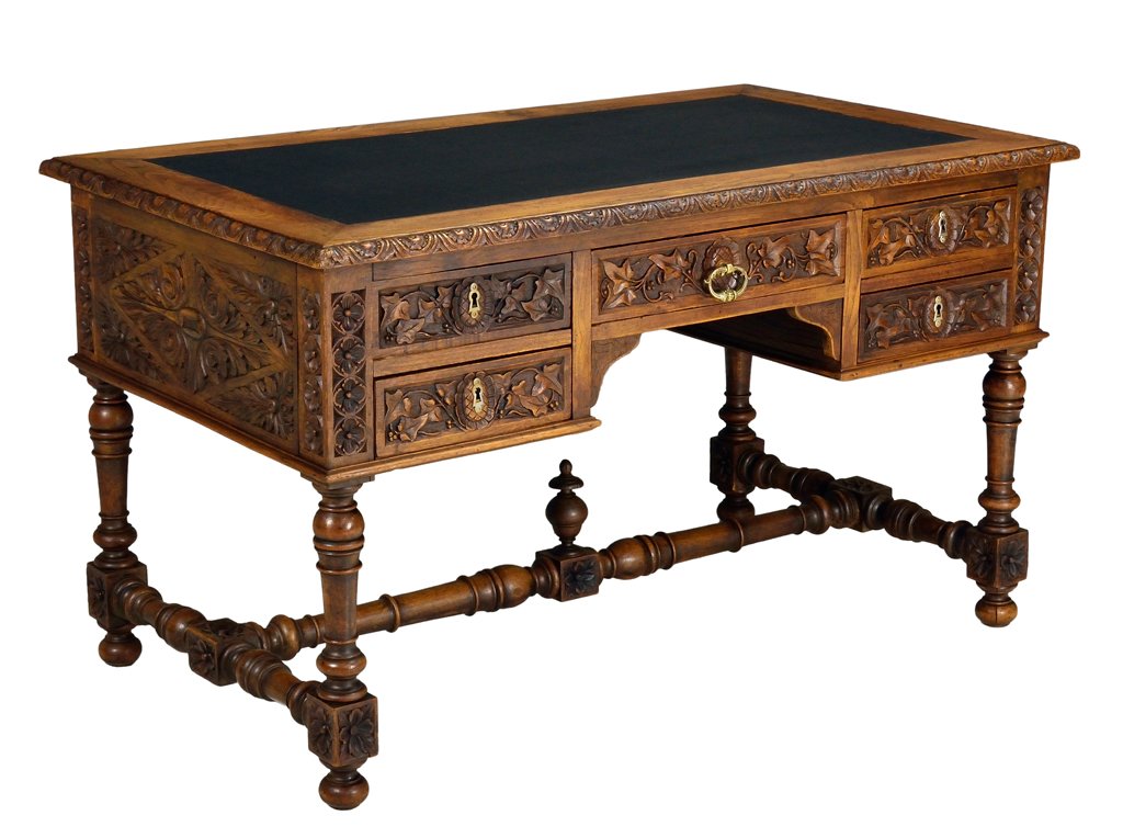 A FRENCH VICTORIAN STYLE FIVE DRAWER CARVED IVY AND LEA: A FRENCH VICTORIAN STYLE FIVE DRAWER CARVED IVY AND LEATHER TOP DESK 19th Century, France A charming French Victorian style desk with inset leather writing surface housing five locking drawers featuri
