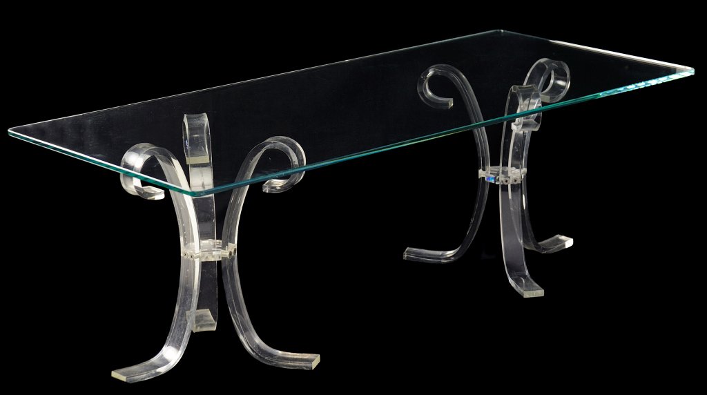 A MODERN ACRYLIC AND GLASS COCKTAIL TABLE Very good con: A MODERN ACRYLIC AND GLASS COCKTAIL TABLE 20th Century For the minimalist, a contemporary small, clear cocktail table with rounded edge cut glass top raised on two curved acrylic tripods with snake fe