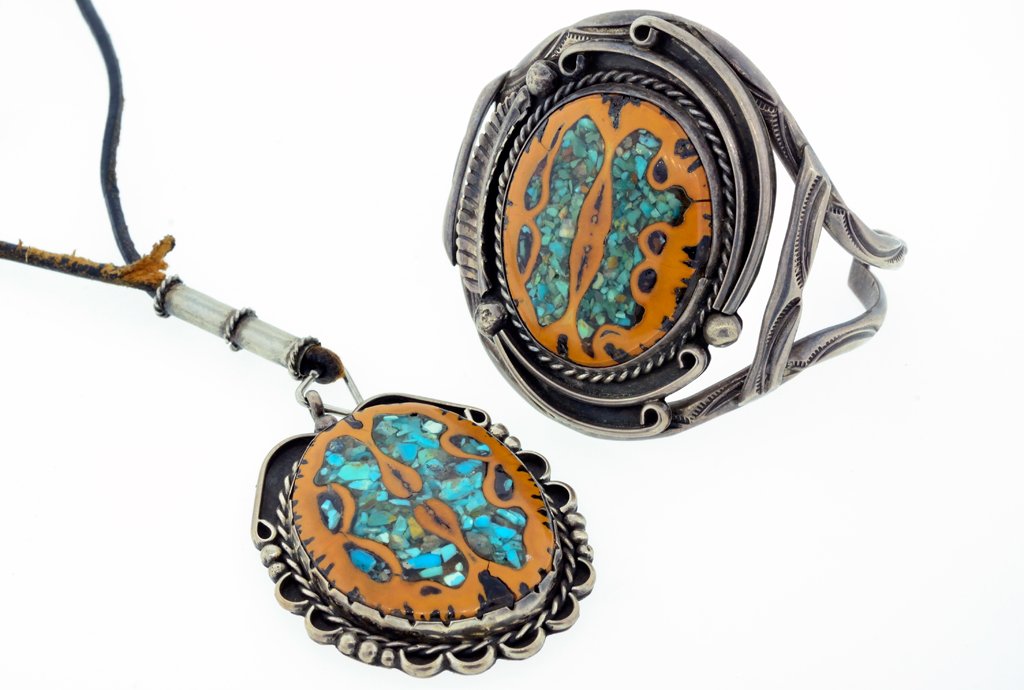 A SET OF VINTAGE NAVAJO TRIBE WALNUT SHELL AND TURQUOIS: A SET OF VINTAGE NAVAJO TRIBE WALNUT SHELL AND TURQUOISE SET The set features a pendant with black cord and a bracelet , designed with walnut shell and tiny pieces of turquoise. Total approx. weight: 