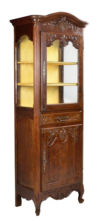 A LOUIS XV STYLE GLAZED SINGLE DOOR SHOWCASE VITRINE Ve: A LOUIS XV STYLE GLAZED SINGLE DOOR SHOWCASE VITRINE Early 20th Century, France A diminutive Louis XV style showcase having a stepped cornice, a carved foliate frieze, a single upper glazed door, a ca