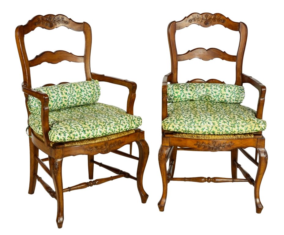 A PAIR OF LADDER BACK RUSH SEAT ARMCHAIRS WITH SHAMROCK: A PAIR OF LADDER BACK RUSH SEAT ARMCHAIRS WITH SHAMROCK Early 20th Century A fine pair of carved ladder back chairs having a carved floral festoon, arching crest rail, a shaped apron, ""H"" style stre