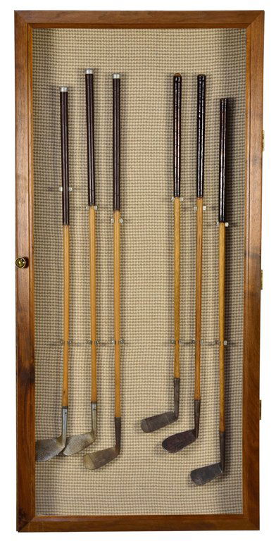 A COLLECTION OF SIX ANTIQUE GOLF CLUBS IN SHADOWBOX: A COLLECTION OF SIX ANTIQUE GOLF CLUBS IN SHADOWBOX Early 20th Century A fine collection of six antique golf clubs have cast putters, and carved wood handles are framed attractively in a shadow box. 5