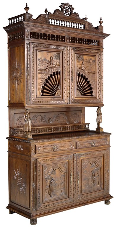 AN ANTIQUE HAND CARVED FRENCH BRITTANY STYLE BUFFET: AN ANTIQUE HAND CARVED FRENCH BRITTANY STYLE BUFFET 19th Century, France An ornately hand carved antique buffet in the French Brittany style is crowned by a finial flanked spandrel cornice, a pierced 