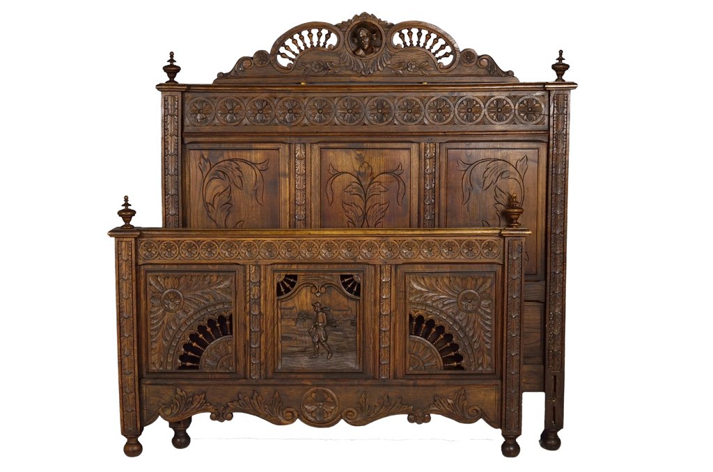A FRENCH BRITTANY STYLE HAND CARVED SPANDREL BED: A FRENCH BRITTANY STYLE HAND CARVED SPANDREL BED Late 19th Century, France A French Brittany style bed has an attached arching crest rail, featuring a center carved portrait medallion in high relief, 