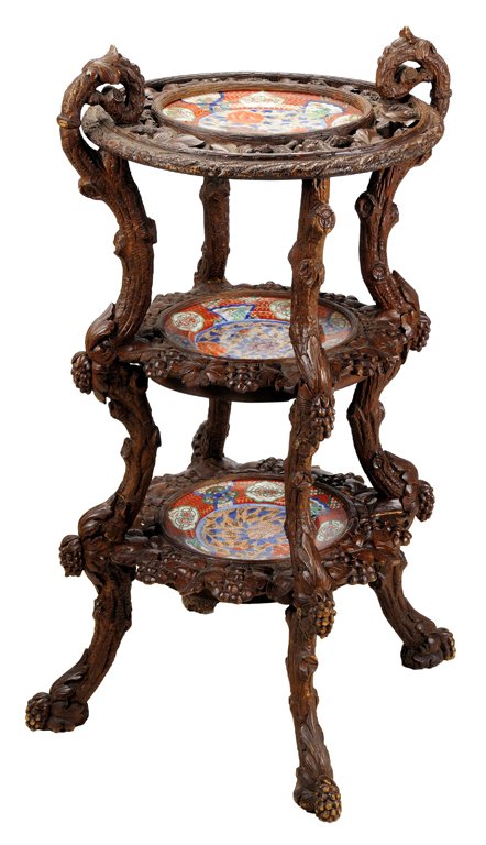 A BLACK FOREST STYLE ÉTAGÈRE Late 19th Century Very goo: A BLACK FOREST STYLE ÉTAGÈRE Late 19th Century A three tier étagère featuring a decorative porcelain plate on each tier encircled by a pierced, ornately carved wood surround in a fruit and foliate