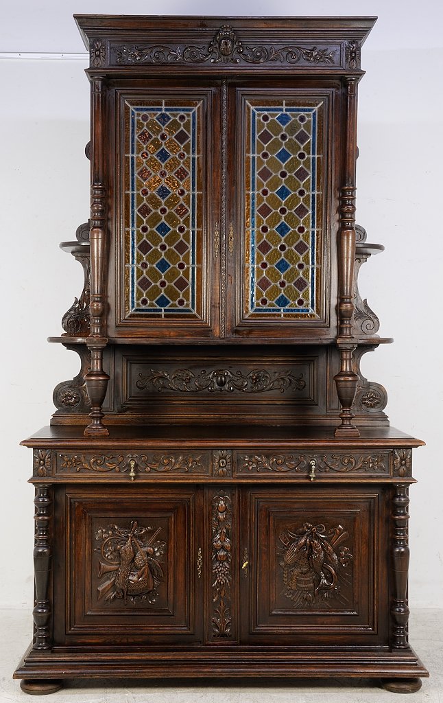 A MULTI COLOR STAINED GLASS ANTIQUE HENRI II STYLE BUFF: A MULTI COLOR STAINED GLASS ANTIQUE HENRI II STYLE BUFFET Early 20th Century A rectilinear cornice with carved egg cartouche is supported by a conforming body featuring a pair of multicolored stained 