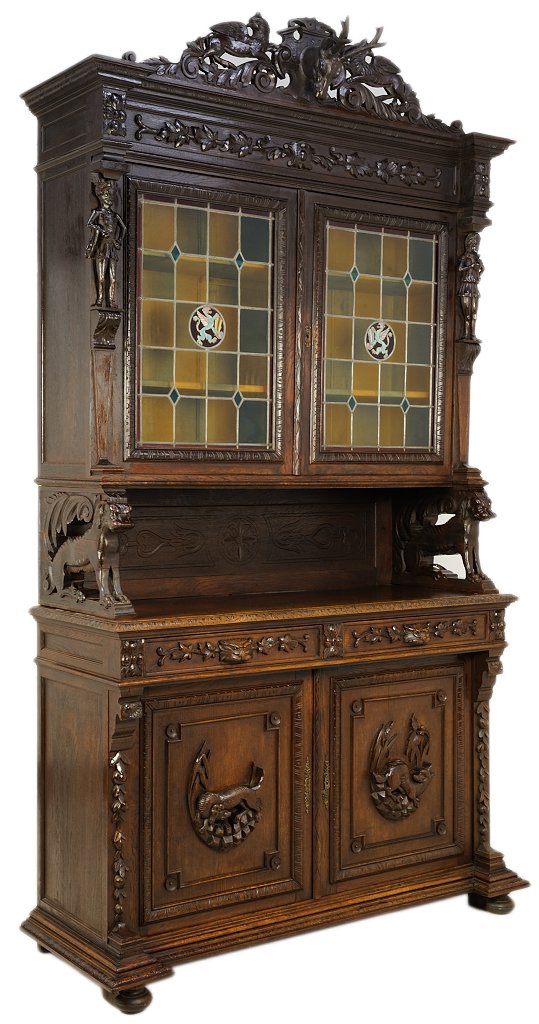 A FINE HENRI II STYLE OAK AND STAINED GLASS SIDEBOARD H: A FINE HENRI II STYLE OAK AND STAINED GLASS SIDEBOARD HUTCH WITH LION, DRAGON AND DOG DETAILS Early 20th Century, France A hand carved stag mount is flanked by griffins and supported by a rectilinear 