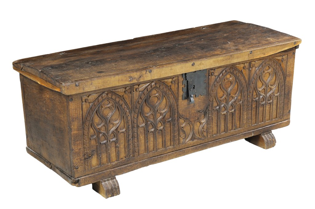 AN ANTIQUE RUSTIC SPANISH GOTHIC STYLE CARVED WOODEN TR: AN ANTIQUE RUSTIC SPANISH GOTHIC STYLE CARVED WOODEN TRUNK 20th Century The trunk features Spanish Gothic style four pointed arch arcade with trefoil carving and an iron closure; raised on block feet.