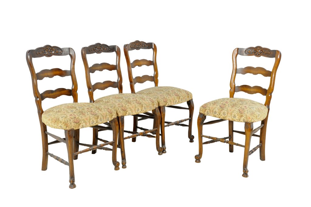 A SET OF FOUR CARVED WALNUT FRENCH PROVENCAL STYLE LADD: A SET OF FOUR CARVED WALNUT FRENCH PROVENCAL STYLE LADDERBACK SIDE CHAIRS Early 20th Century A set of four antique carved walnut French provencal style ladder back side chairs features a provincial st