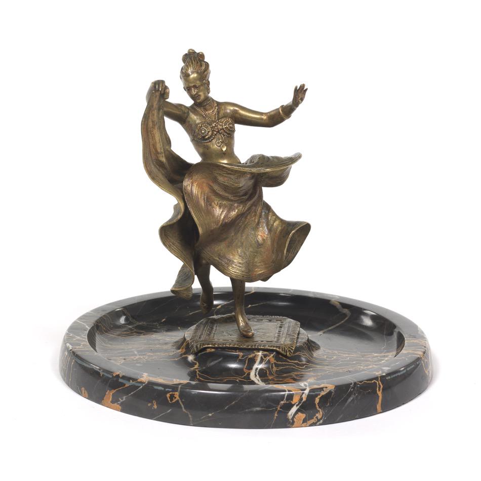 Austrian Bronze Dancer Sculpture with Articulated Skirt: 8" x 9" Austrian bronze sculpture of a harem dancer in the style of Franz Bergman, with a long flowing skirt that swings open to reveal her nude torso, on heavy black mottled marble base, ca. 1920's.