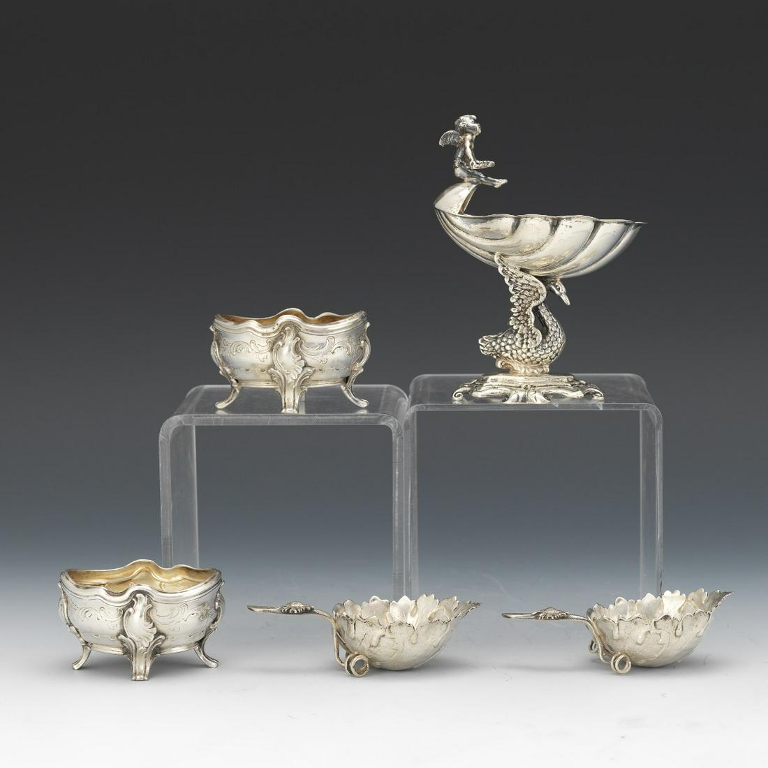 Five Silver Salt Cellars: Two by J. Piault, with Minerva head mark, 1-1/2" x 2-5/8" x 2". Two Hanau leaf shaped salt cellars, 1-1/4" x 3-3/4" x 1-7/8". One German master salt cellar of a shell on a swan pedestal with cherub ha