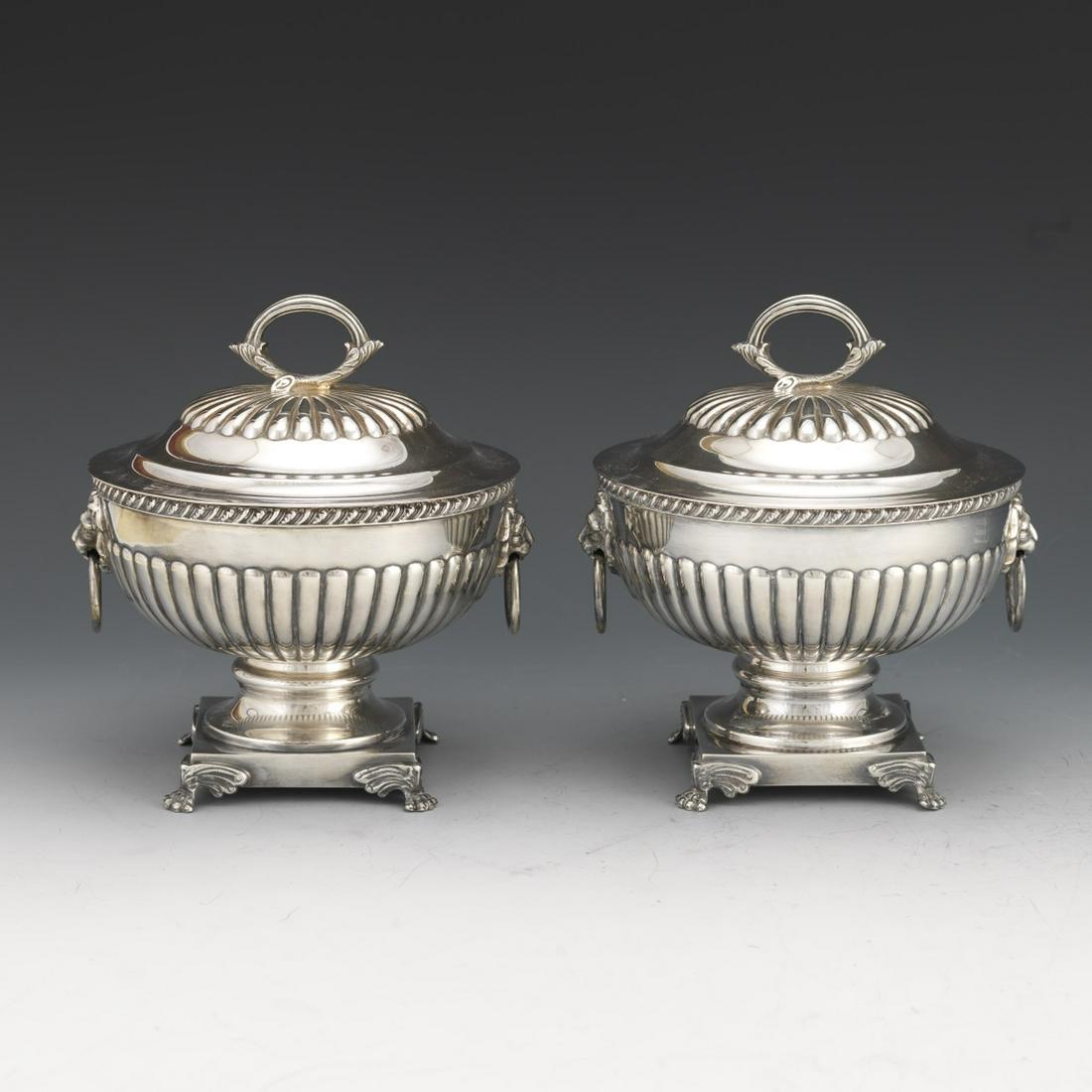 English Georgian Style Silver Plated Pair of Sauce: 6-7/8" x 6-1/2" x 5-7/8" Traditional Georgian style silver plated pair of tureens, fluted design, lift up domed cover with openwork cast finial, two handles, fashioned as lion heads with rings, on ste
