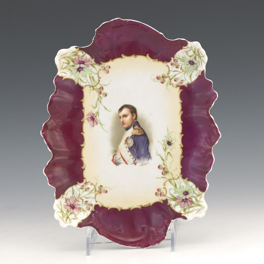 Portrait Plate of Napoleon: 10-1/8" x 8" Porcelain plate with shaped rim, maroon border and central with portrait of Napoleon, signed monogram "CD". Partial Austrian mark to the underside, probably the factory Moritz Zdekauer, a