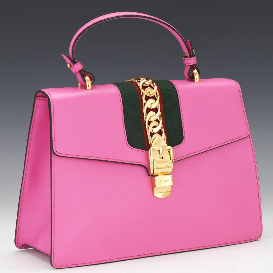 Gucci Sylvie Pink Leather Crossbody Bag: 9" x 12-1/2" x 5" Gucci pink leather shoulder bag with web accent and Sylvie web accent, gold-tone hardware, top handle, suede lining and interior pocket and card slots, flap closure at front. Paper c