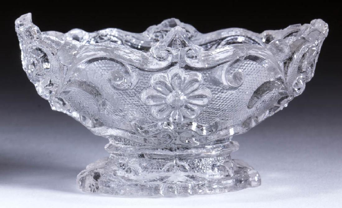OP-8 DAISY AND SHELL OVAL PEDESTAL PRESSED OPEN SALT: OP-8 DAISY AND SHELL OVAL PEDESTAL PRESSED OPEN SALT, colorless, shaped rim. Rare. Possibly New England area. 1835-1850. 1 7/8" H, 2" x 3 1/4".Near proof, one central side-rim point tipped, shallow in