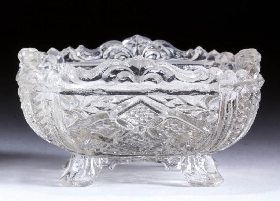 OP-17 OVAL PEDESTAL PRESSED OPEN SALT: OP-17 OVAL PEDESTAL PRESSED OPEN SALT, colorless, complex scrolled rim, raised on four splayed feet. Scarce. Possibly Boston & Sandwich Glass Co. 1830-1845. 1 7/8" H, 2 5/8" x 3 1/2". Near proof havin