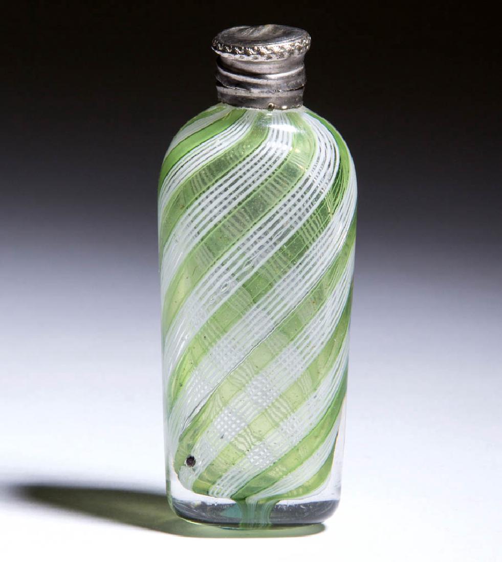 LATTICINIO DECORATED PUNGENT / SCENT BOTTLE: LATTICINIO DECORATED PUNGENT / SCENT BOTTLE, colorless with swirled light green ribbons alternating with opal threads, flattened oblong form with hinged silver-plate cap, lacking interior stopper. Fou