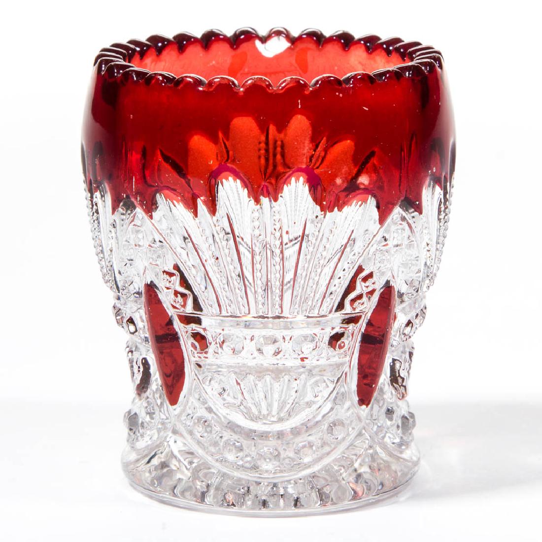 HEISEY NO. 335 / PRINCE OF WALES - RUBY-STAINED: HEISEY NO. 335 / PRINCE OF WALES - RUBY-STAINED TOOTHPICK HOLDER, colorless. A. H. Heisey & Co. Circa 1902. 2 3/8" H.Nearly undamaged with a single chip to the rim.Literature: Parallels Bredehofts/San