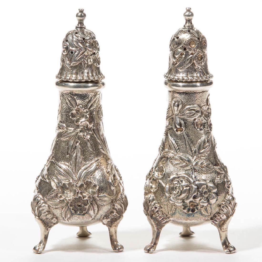 S. KIRK AND SON CO STERLING SILVER PAIR OF SALT AND: S. KIRK AND SON CO STERLING SILVER PAIR OF SALT AND PEPPER SHAKERS, baluster form raised on tripod legs, lift-off cap, repousse overall floral pattern on a lightly stippled field, underside impressed 