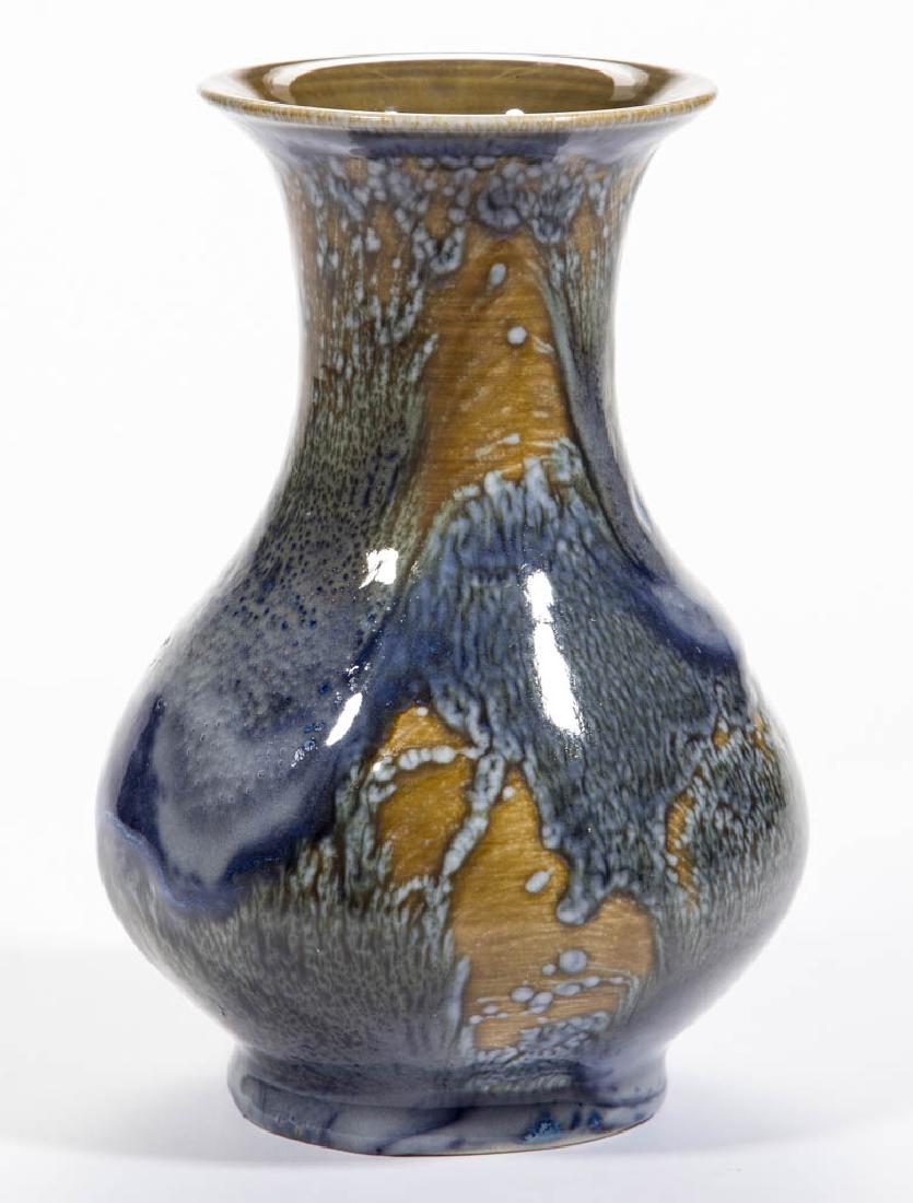 ROOKWOOD MENZEL ART POTTERY VASE: ROOKWOOD MENZEL ART POTTERY VASE, having a mottled and flowing blue and green glaze over a light brown ground. Artist signature for Ruben Earl Menzel with intertwined "REM". Marked with impressed Rook